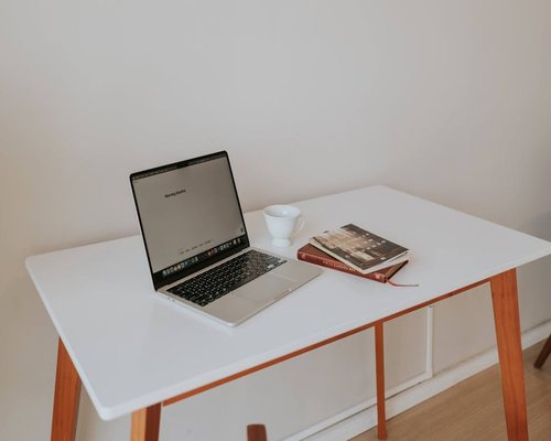 A desk with an open laptop and coffee